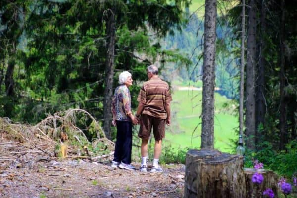 Eldery couple hiking in the woods while preventing a fall