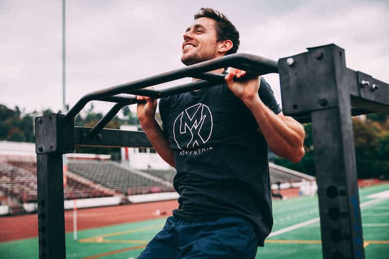 Man in a MovementX shirt doing pullups