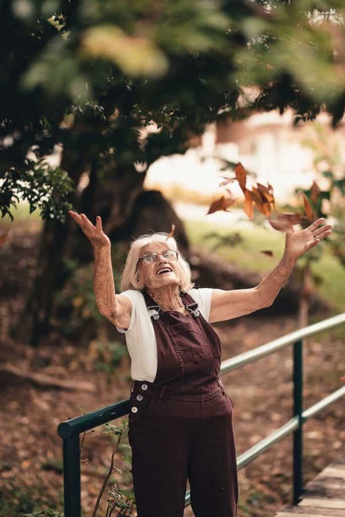 Older woman with great balance throwing leaves without falling