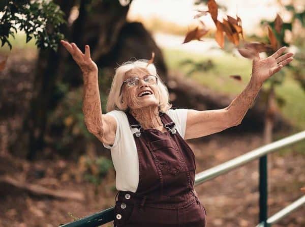 Older woman with great balance throwing leaves without falling