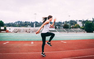 Woman with forward lean performing running drills