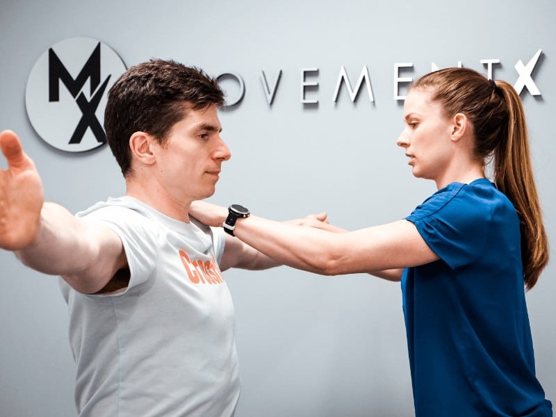 female physical therapist applying shoulder resistance to male patient with rotator cuff injury
