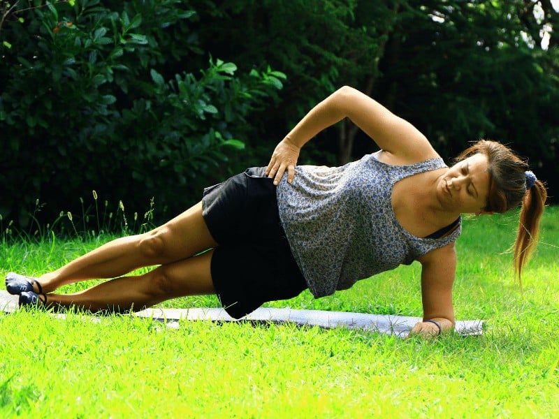 pregnant woman performing a side plank exercise to strengthen her hips