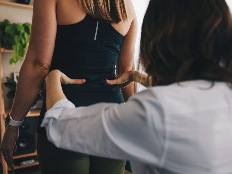 MovementX physical therapist performing an examination on a pregnant woman with lower back pain to help with pain relief