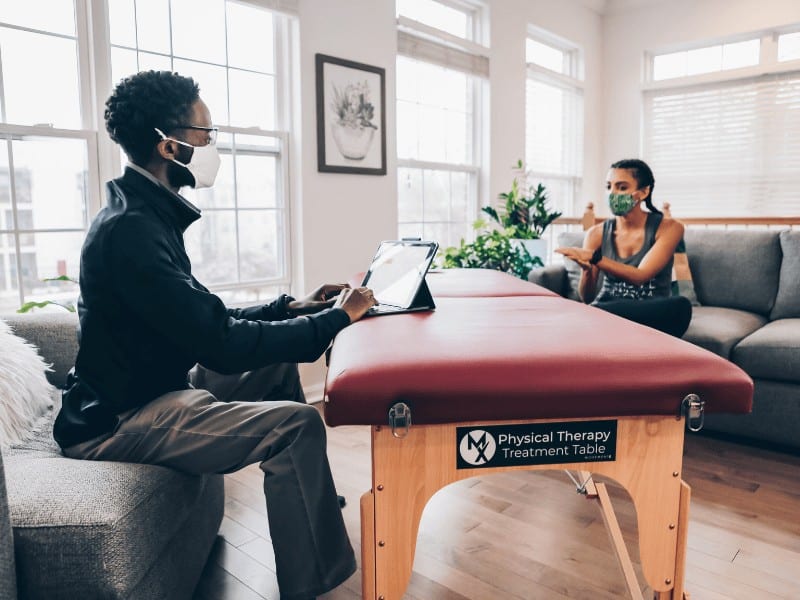 MovementX physical therapist and ergonomics specialist performing an examination on a patient with posture related pain