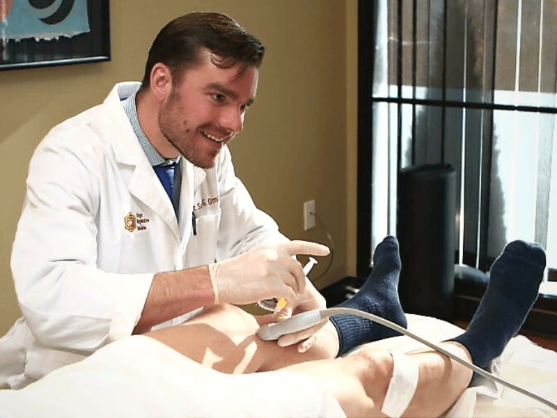 Dr. Sam Oltman performing a regenerative medicine treatment on a patient in Portland Oregon