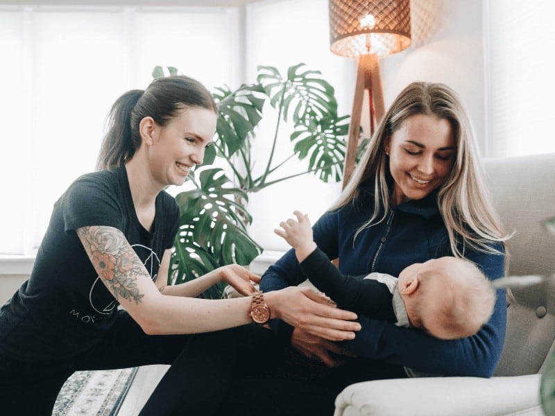 MovementX physical therapist working with her patient and her patient's newborn baby after pregnancy