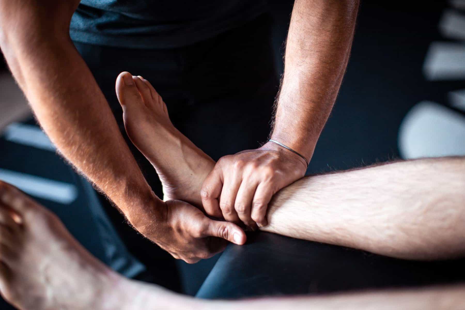physical therapist performing hands on manual therapy with a patient with plantar fasciitis pain close up shot