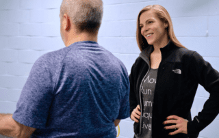 MovementX personal trainer Meredith Black smiling at a patient wearing a blue shirt during a personal training in northern virginia session