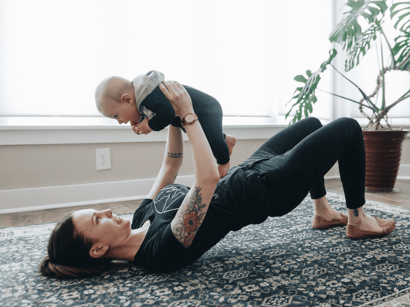 A new mother playing with her baby boy after working with MovementX pelvic health physical therapy