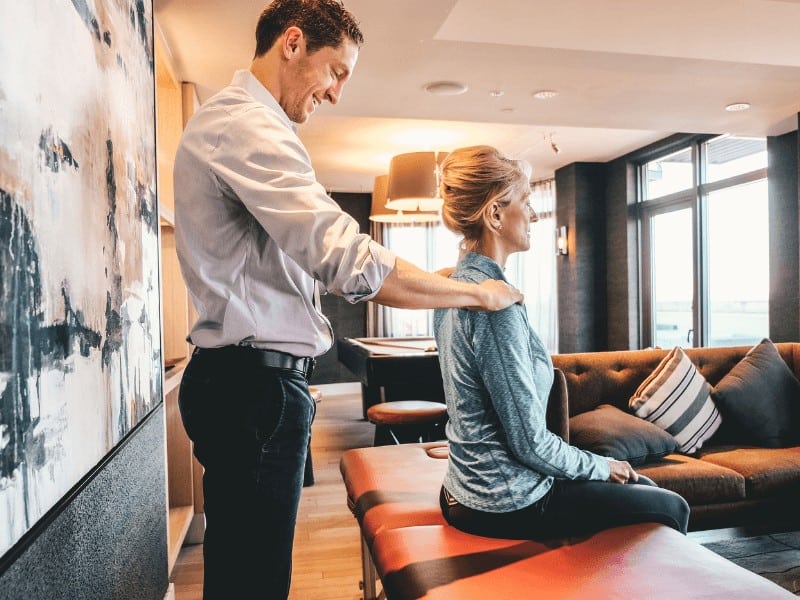 Physical therapist with MovementX scott mcafee treating an older adult patient with neck pain with personalized at home physical therapy treatment