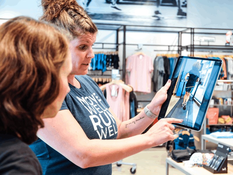 MovementX running physical therapist meg pezzino performing a running gait analysis and showing an ipad with the results to a runner in northern virginia