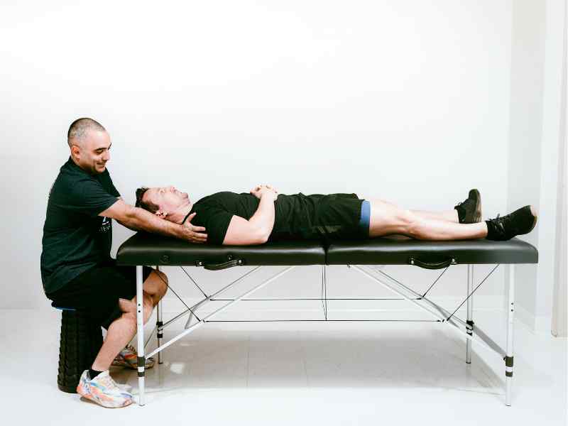 Romin Ghassemi, PT, DPT working through a shoulder mobility and treatment assessment with a patient on a treatment table in North Carolina.