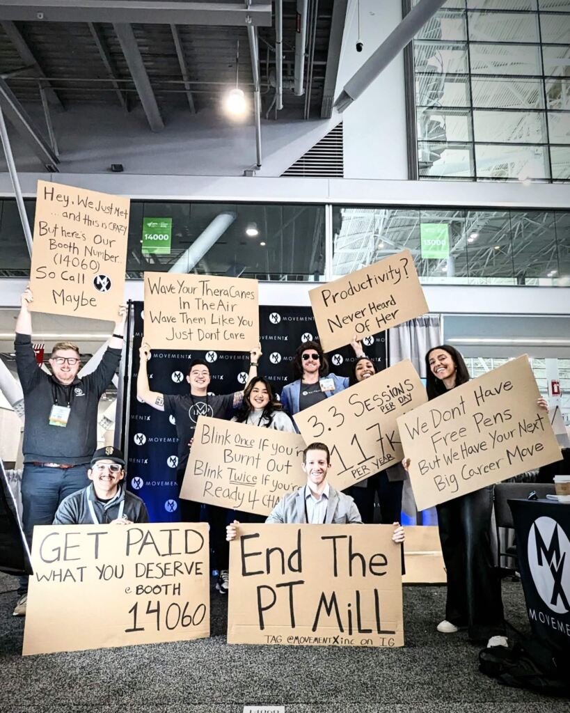 The MovementX team all holding cardboard signs at CSM Boston 2024.
