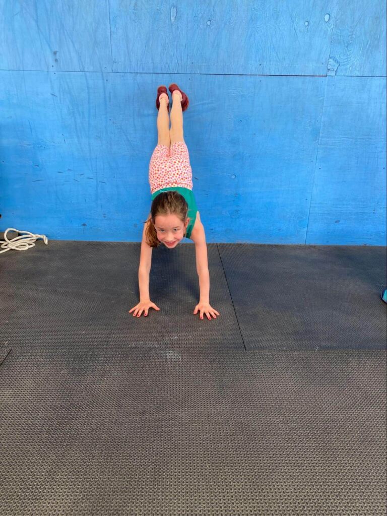 A child doing a wall handstand.