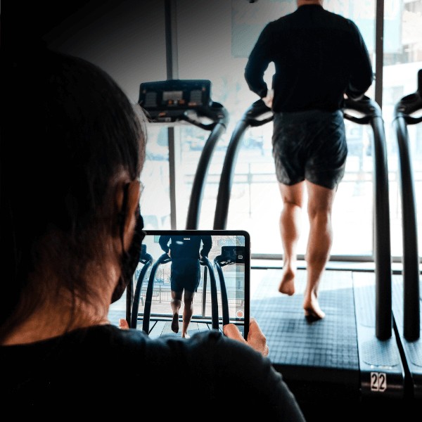 A MovementX orthopedic physical therapist conducting a running gait analysis on a treadmill to optimize a patient's stride and prevent injury.