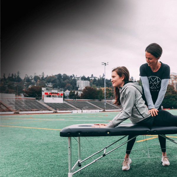 a movementx physical therapist treating a patient in the middle of an athletic field