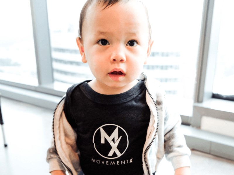 A young kid wearing a movementx shirt in a clinic setting.