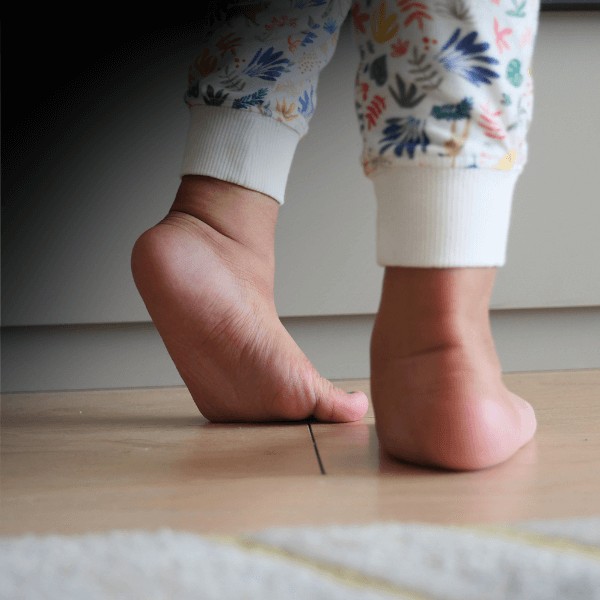 A close up picture of a young child's feet while walking