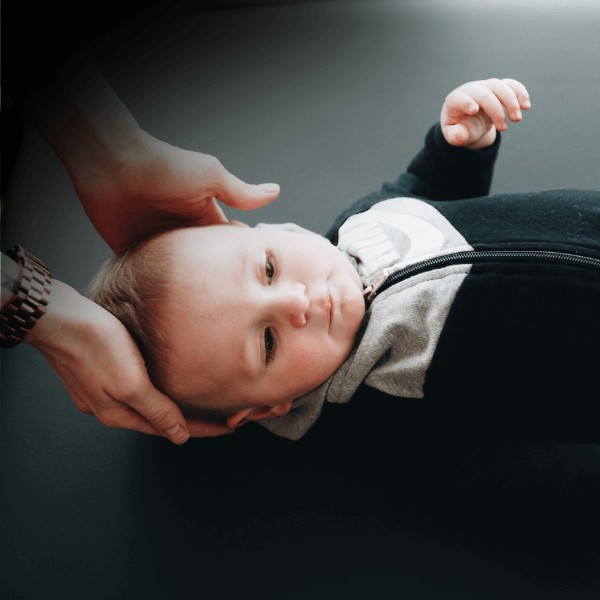 A MovementX pediatric physical therapist diagnosing and treating torticollis with specialized exercises and positioning techniques to improve a child's neck mobility.