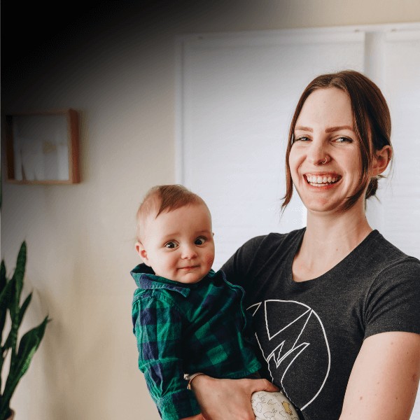 Mother smiling with her young son postpartum after getting movementx physical therapy.