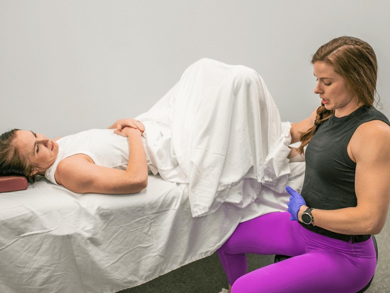 MovementX therapist zoe pond mcpherson performing an internal pelvic floor treatment technique on a female with pelvis pain.