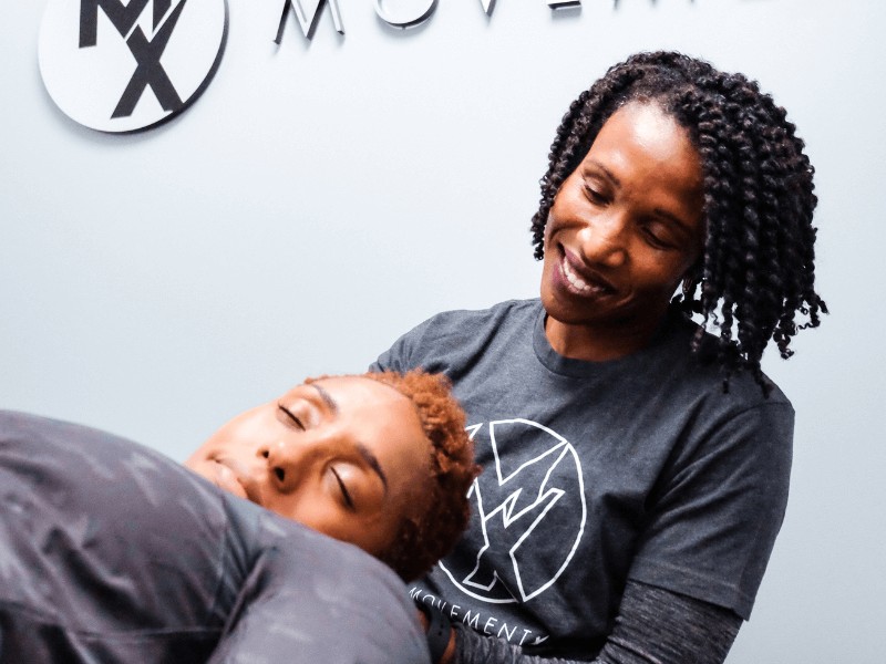 A movementx vestibular physical therapist performing manual therapy to a patient's neck to alleviate headaches in a clinical setting