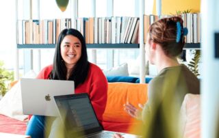 Two MovementX employees, Mandy Teng and Theresa Nelson, working together in a coworking office.