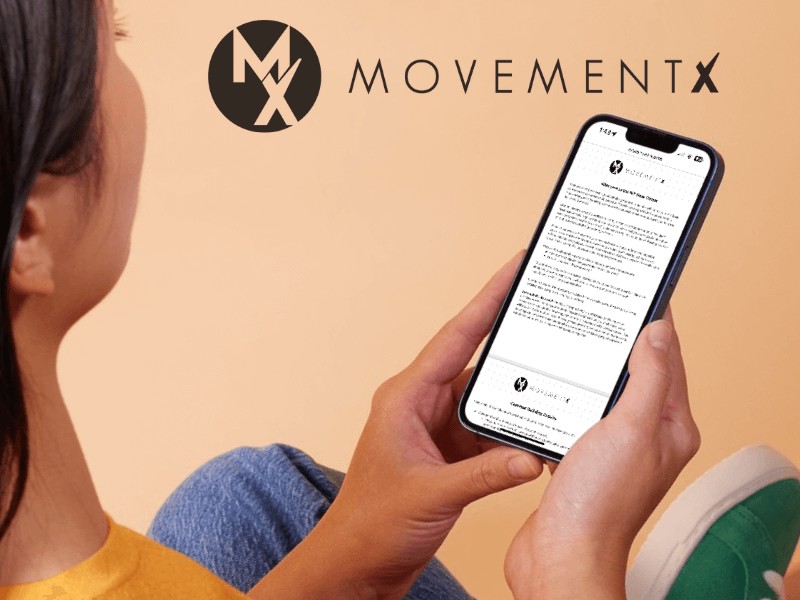A physical therapist holding a phone after downloading the movement base camp activity to grow their private PT practice patient caseload