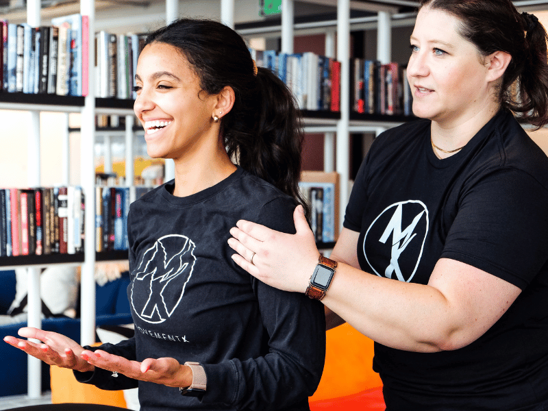 A MovementX physical therapist laughing with a patient during a treatment in the patient's place of work.