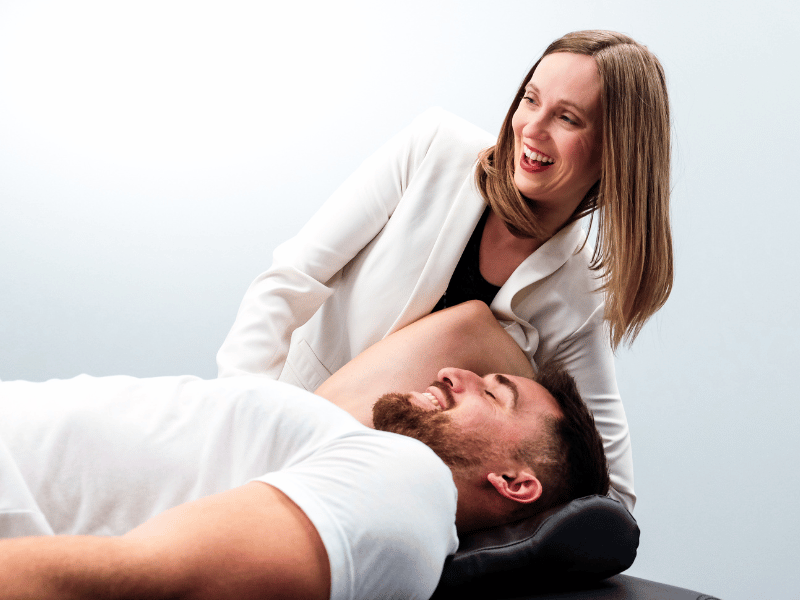 A MovementX provider and a patient laughing together while doing a diagnostic test and talking in-home.