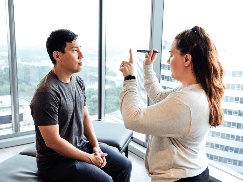 A MovementX provider helping examine a patient for balance issues during a physical therapy consultation.