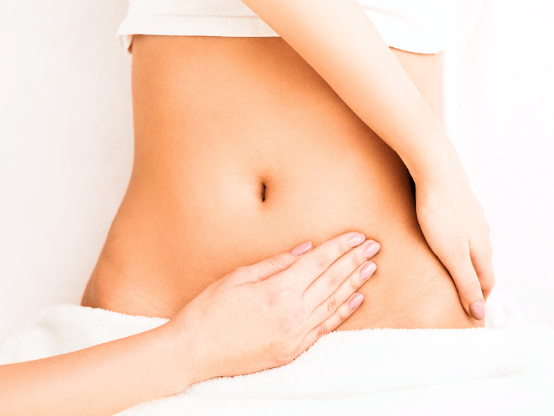 A physical therapist giving an abdominal massage to a patient.