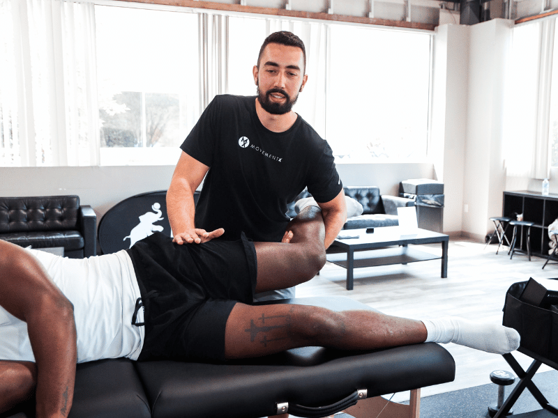 Patrick Dumais, PT, DPT doing a leg manipulation on a physical therapy table.