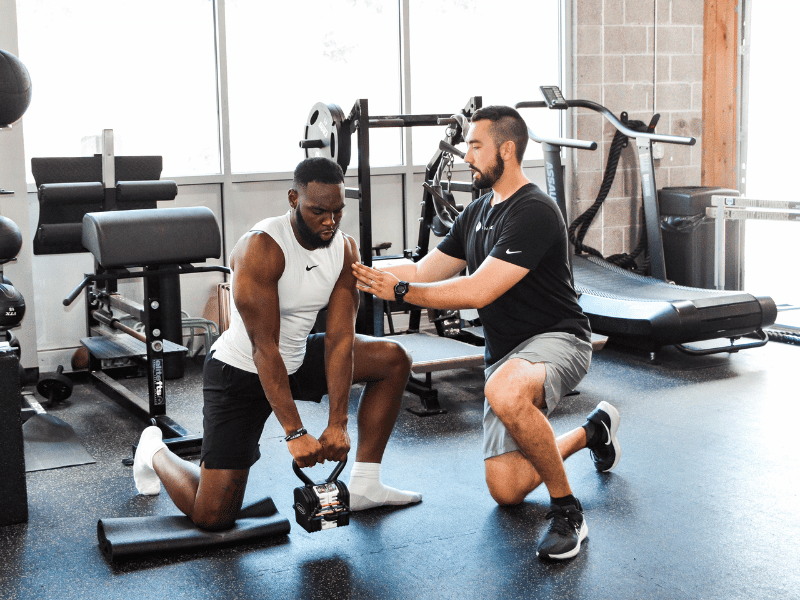 Patrick Dumais, PT, DPT helping a patient move through a lateral knee exercise in his clinic in Pittsburgh, Pennsylvania