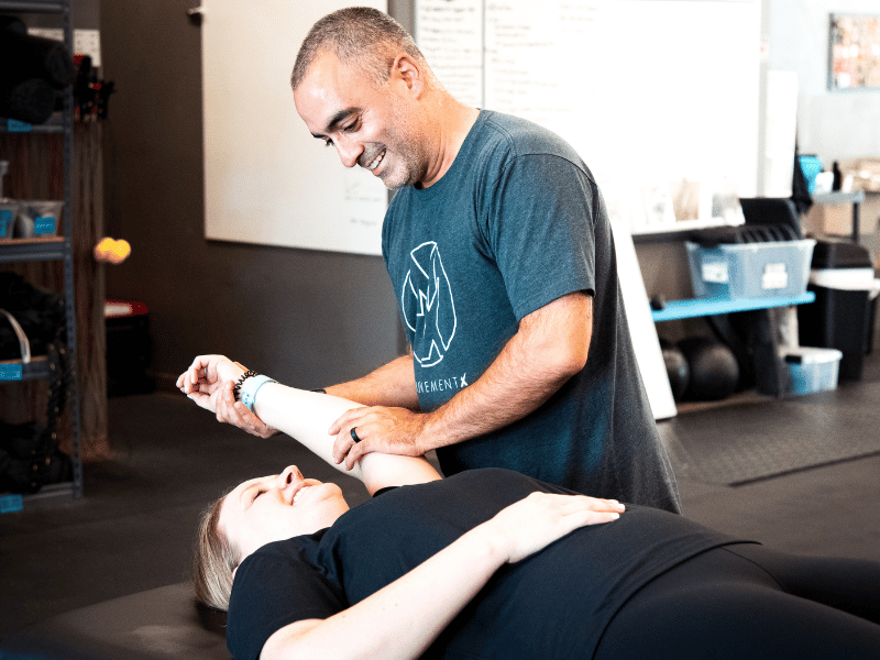 Romin Ghassemi, PT, DPT helping a patient mobilize their tennis elbow in a physical therapy session.