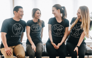 a group of four movementx physical therapists sitting on a treatment table