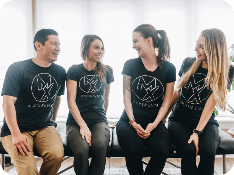 a group of four movementx physical therapists sitting on a treatment table in portland oregon