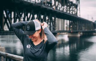 a female movementx physical therapist standing beside a bridge in the rain in portland oregon