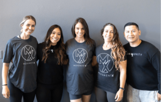 A team of 5 movementx physical therapists smiling wearing attire from their PT job