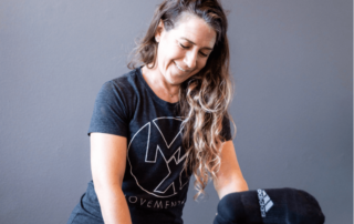 a movementx physical therapist treating a patient while wearing a shirt with the logo of her PT job in oregon