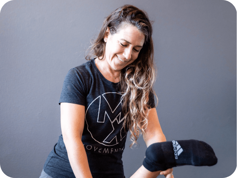 a movementx physical therapist treating a patient while wearing a shirt with the logo of her PT job in oregon