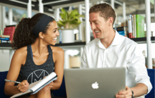 two newly hired movementx physical therapists learning their PT jobs and talking with each other in a work setting