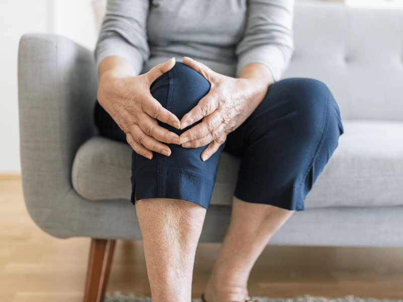 A woman holding her knee in pain.