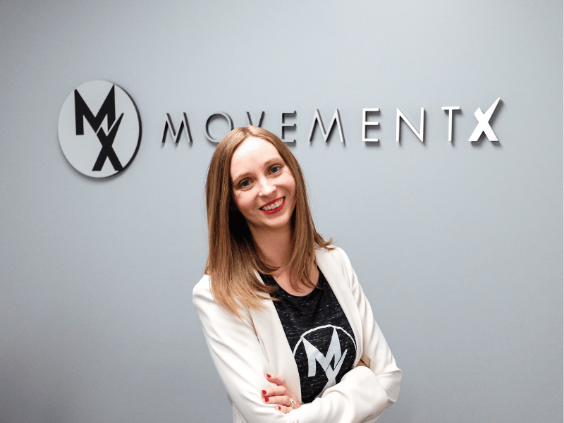 Dr. Stephanie Weyrauch standing in front of the MovementX logo in Billings, Montana.