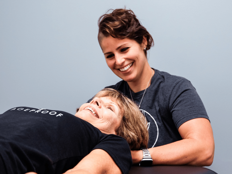 Emily Harmon, PT, DPT, helping a patient on a treatment table.