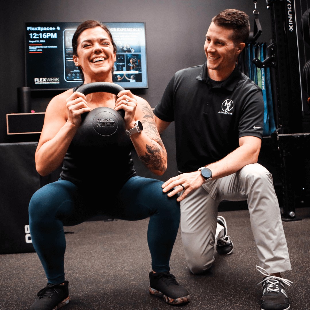 Adam Kays with MovementX physical therapy near Noblesville, IN instructing a female patient about kettlebell exercises to strengthen her hips