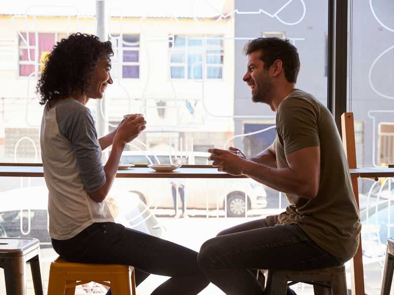 A man and a woman on a date in a coffee shop.