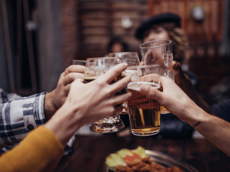 A group of friends toasting their drinks in the early evening to avoid sleep impacts.