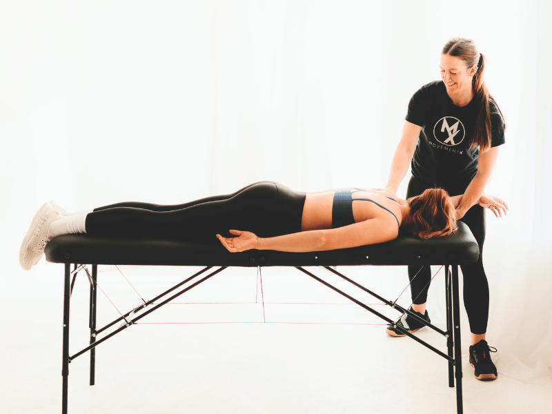 A MovementX Doctor of Physical Therapy helping a patient maneuver through a shoulder pain treatment plan.